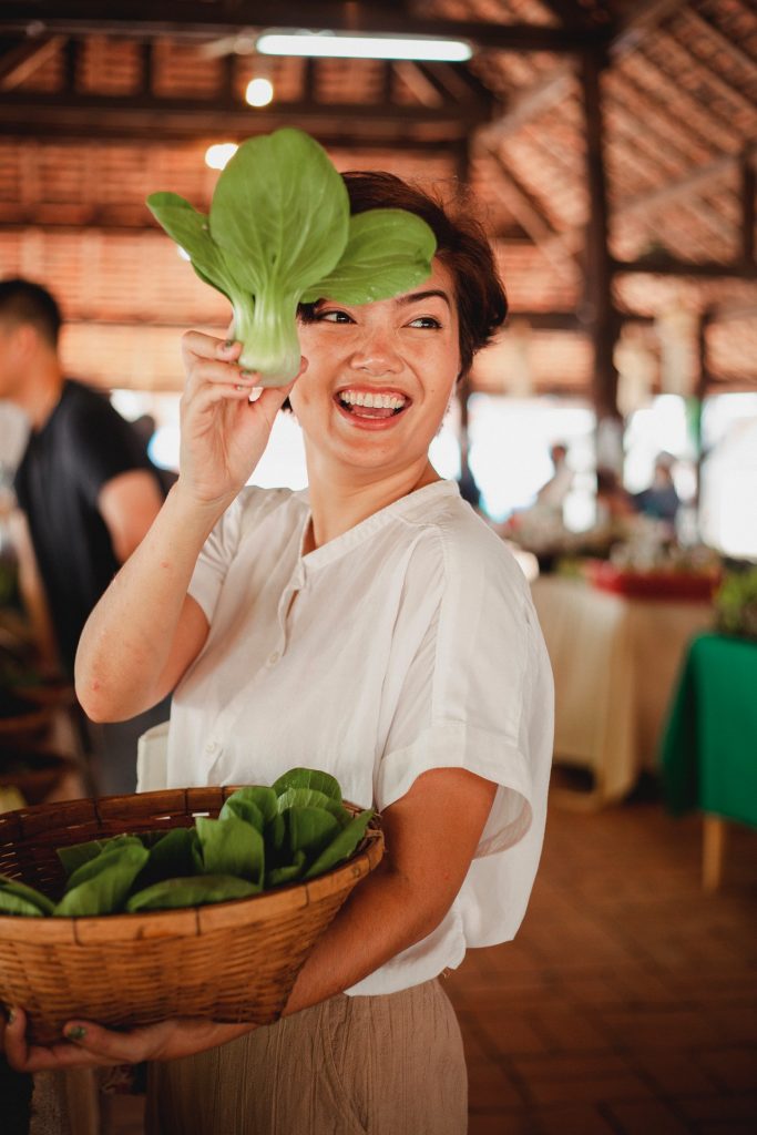 Happy woman holding salad leaf